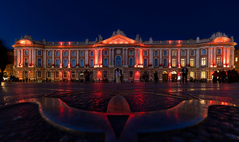 Photo montrant la façade du Capitole éclairée en rouge et noir, le soir du vendredi 24 mai, en soutien au Stade Toulousain